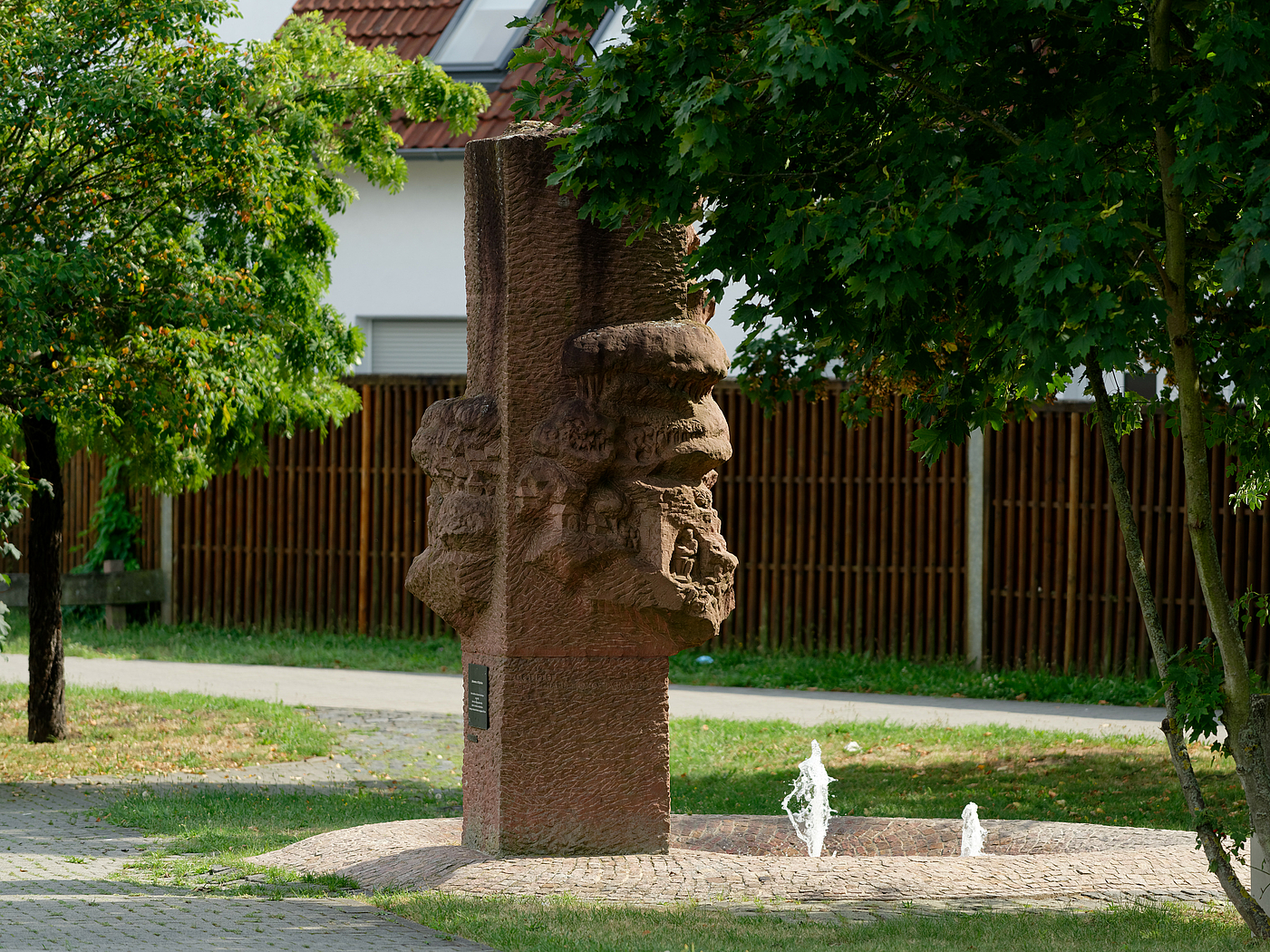Steinskulptur mit Alltagsszenen.